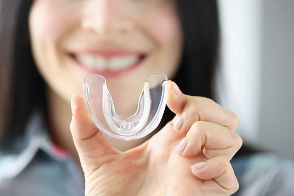 Close up of a simple mouthguard being held up by a woman